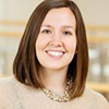 Headshot of Meghan M. Burke, a white woman with brown shoulder legnth hair wearing a blouse and smiling at the camea. 